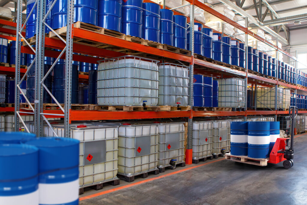 Chemical warehouse. Barrels with flammability symbol. Forklift in warehouse area. Oil barrels are stored on racks. Warehouse hangar inside. Interior industrial chemical storage facility. 3d image